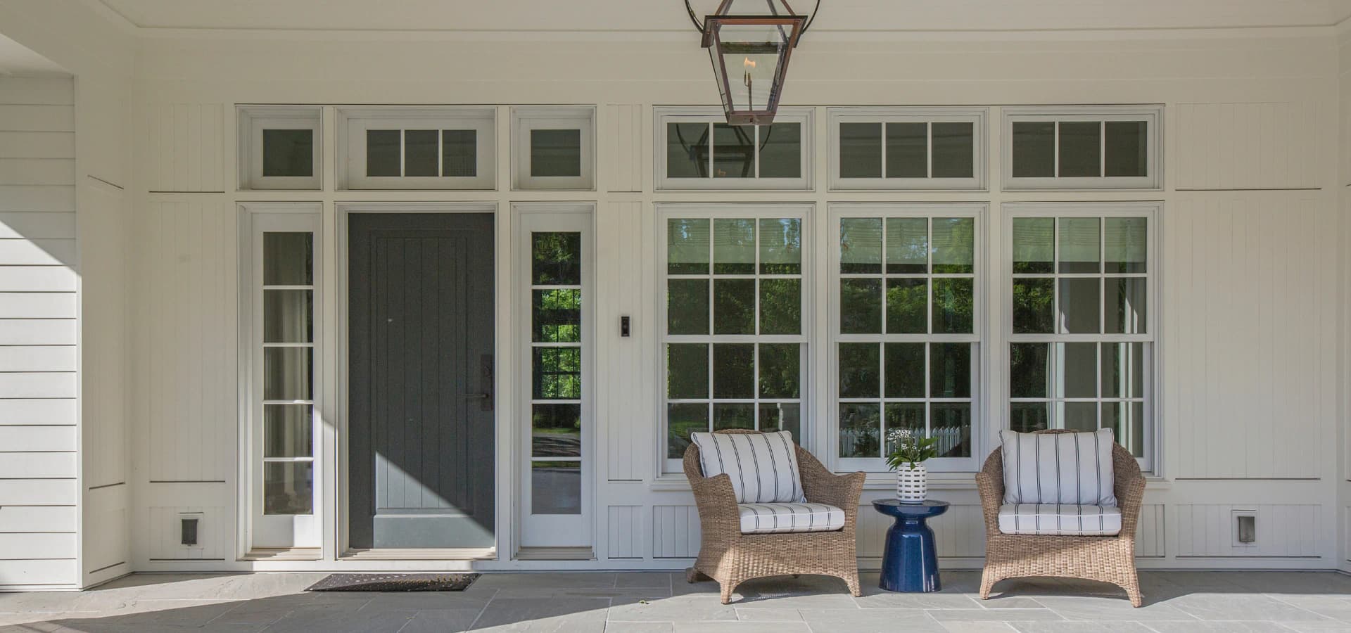 White front porch with a new entry door, sidelights and windows